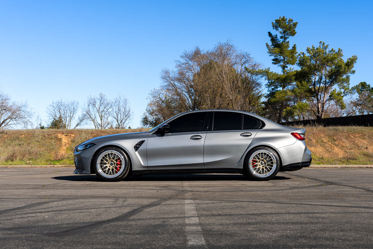 En bild på bmw m3 g80 som är fotad från sidan med bbs fälgar 